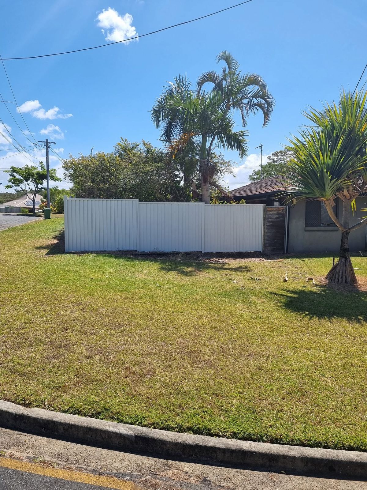 Long cream Colorbond fence wrapping a corner block